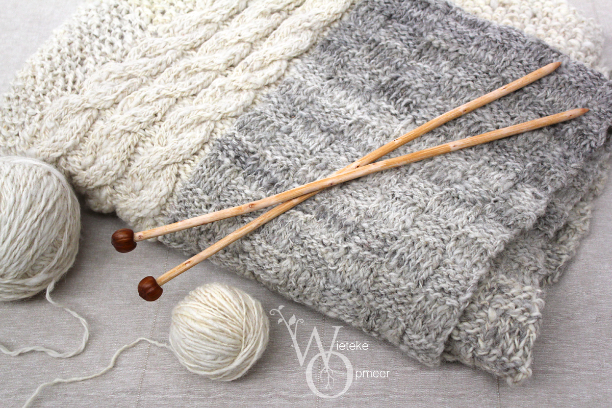 a set of wooden, hand carved organically shaped knitting needles with acorn ends